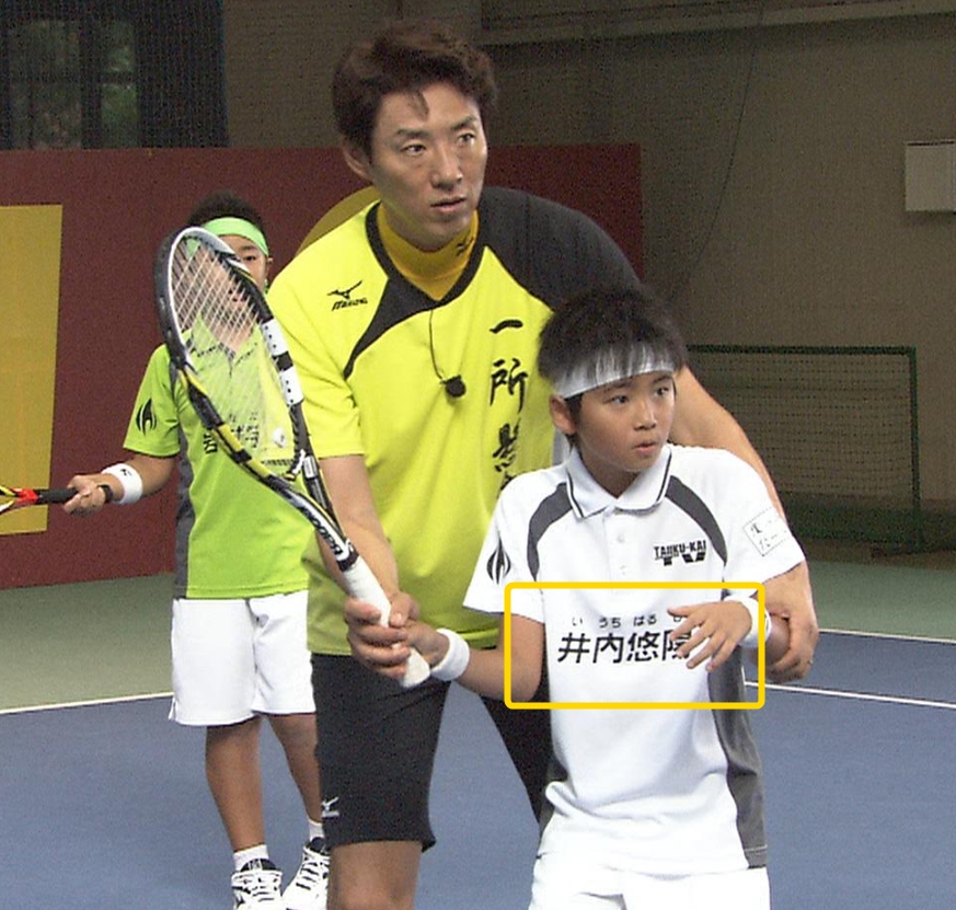 テニスのコーチと教わる少年